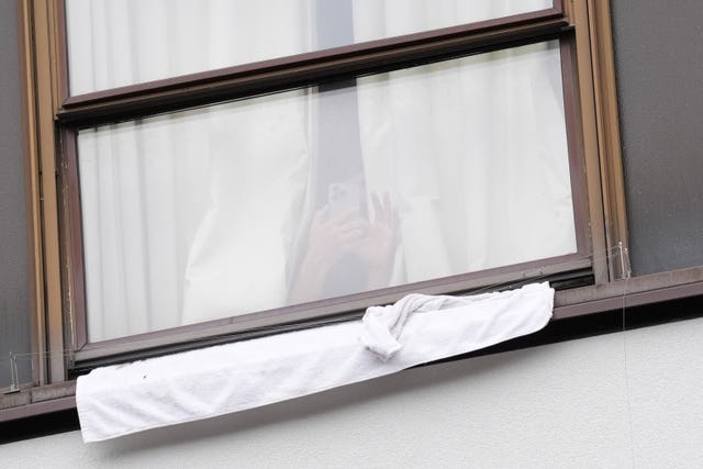 Hotel residents watch from the window as protesters gather outside