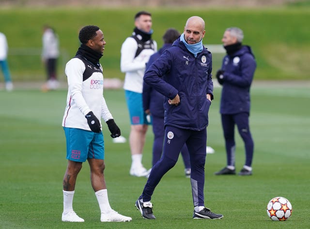 Pep Guardiola talks to Raheem Sterling in training at City