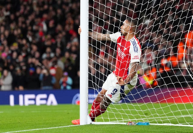 Gabriel Jesus holds onto the post as he falls into the net