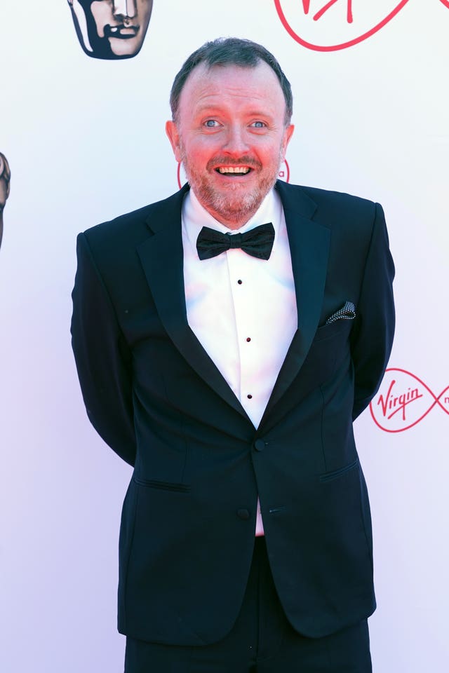 Comedian Chris McCausland in front of Bafta backdrop