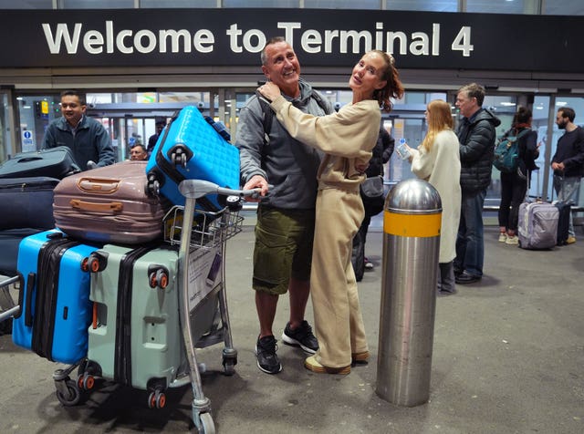 Two people with lugage hugging