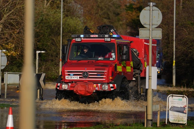 A firefighter driving through a flood