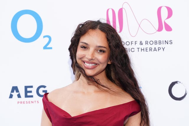 Jade Thirlwall smiling in a red gown