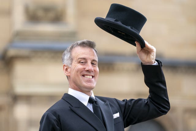 Anton Du Beke smiling and holding a top hat in the air