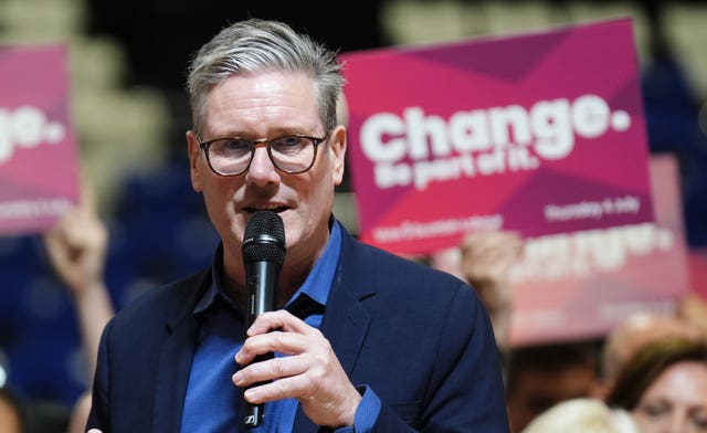 Sir Keir Starmer speaks into a microphone in front of a crowd