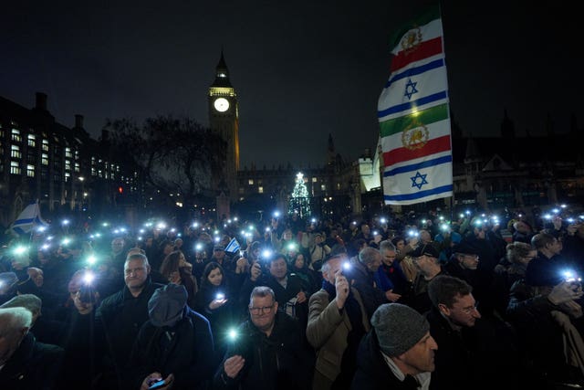 People hold phone torches in the dark 