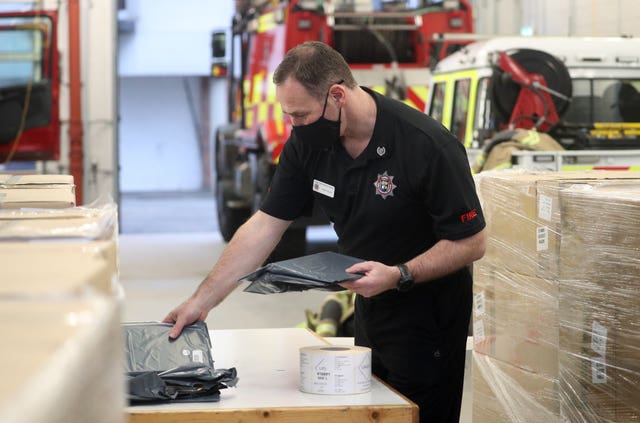 Surrey Fire and Rescue group commander David Nolan sorts through Covid-19 home testing kits at Woking Fire Station 