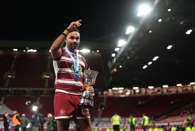 Bevan French raises his right hand as he holds the Super League trophy in his other hand