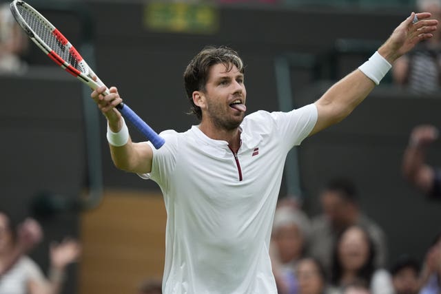 Cameron Norrie holds his arms aloft in celebration