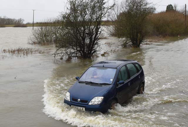 A car struggles through the water at Sutton, Cambridgeshire (Ben Birchall/PA)