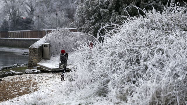 A walker photographs the snow and frost in Marchwood near Southampton