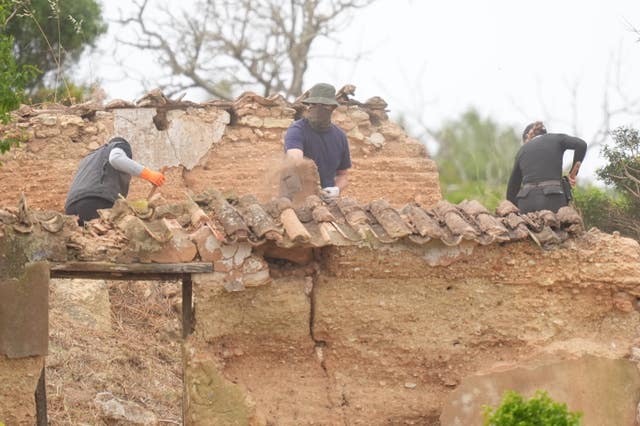 Search teams using shovels as they work at an abandoned building