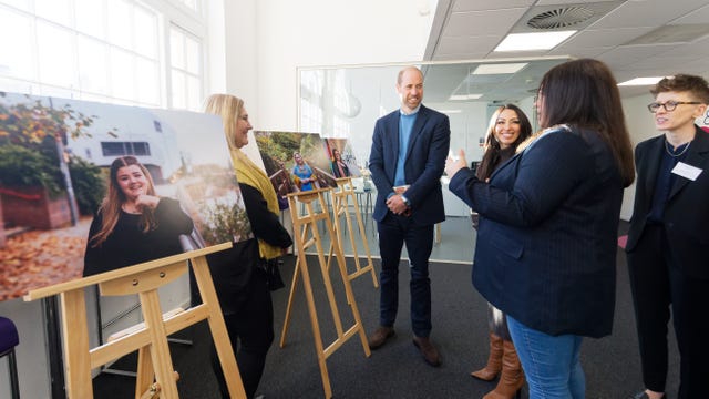 Prince of Wales speaks to woman at photo exhibition