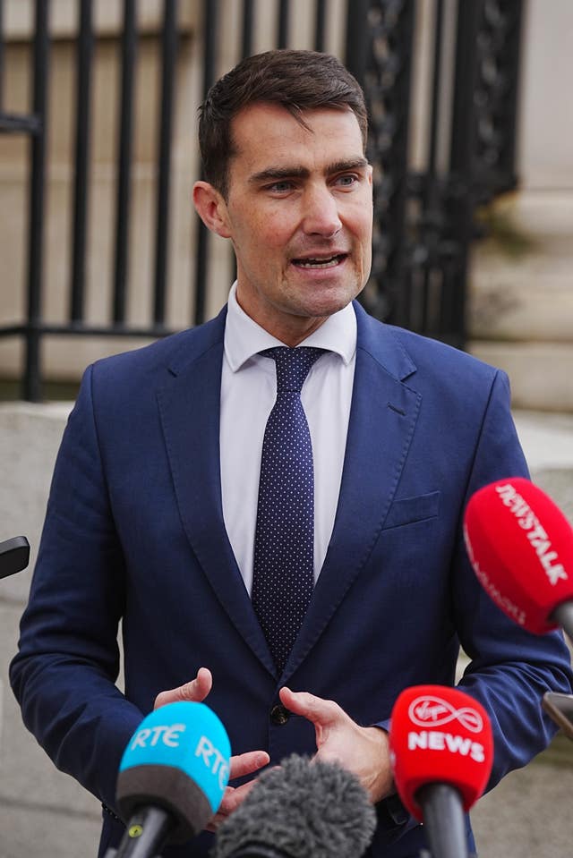 Jack Chambers speaking into a bank of microphones outside a building