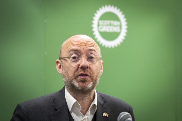 Patrick Harvie against a green backdrop