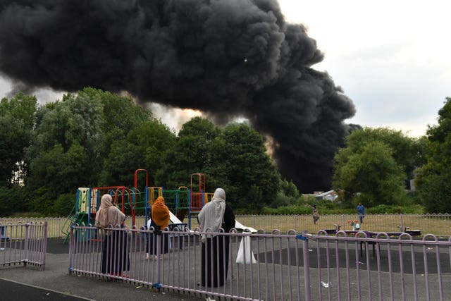 People watch on as smoke billows from a severe blaze on an industrial estate in Birmingham 