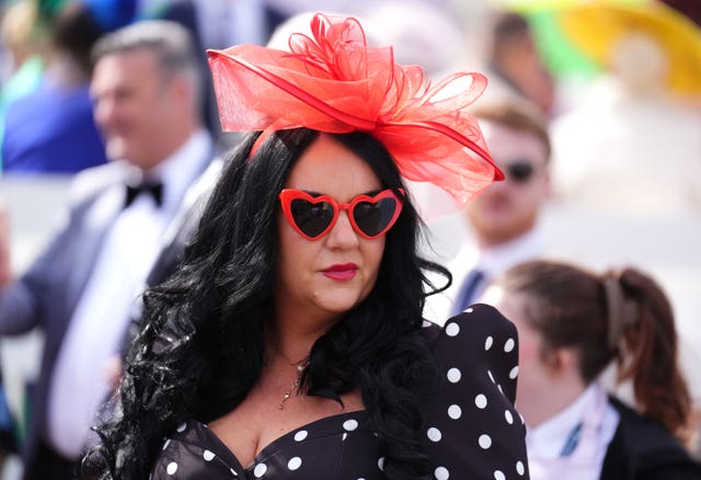 A woman in a polka dot dress and red sunglasses