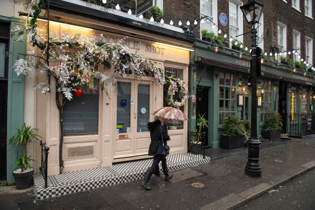 A woman passes closed pubs and restaurants in Covent Garden, London.