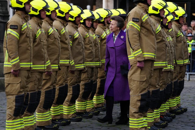 HRH The Princess Royal walking along a row of firefighters dressed in full kit