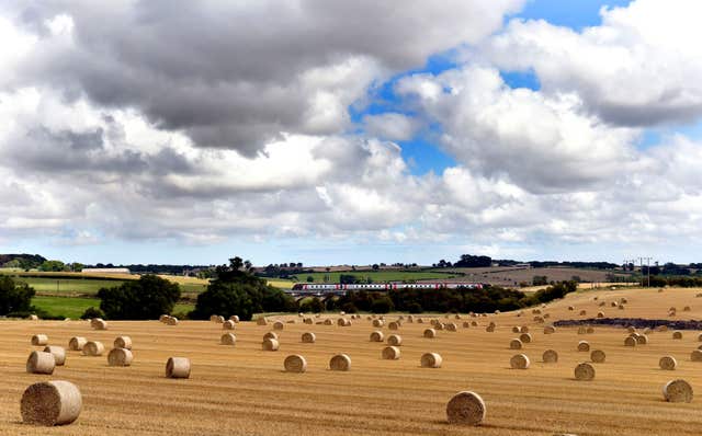 A train runs along the mainline in front of newly harvested fields near Darlington, County Durham 