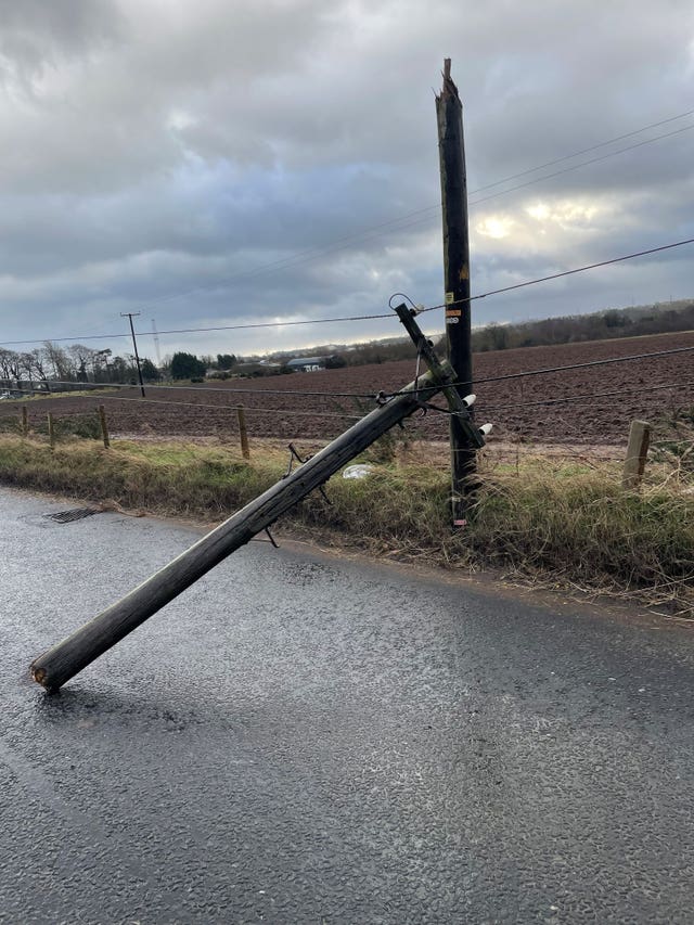 A telegraph pole is on its side covering the road