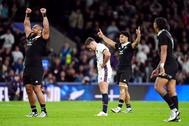 George Ford looks to the ground after missing a late drop goal as New Zealand players celebrate