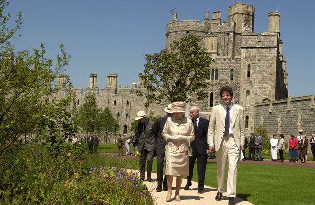 Queen Elizabeth II is shown around the Jubilee Garden inside the grounds of Windsor Castle by Tom Stuart-Smith in the sunshine with the castle in the background