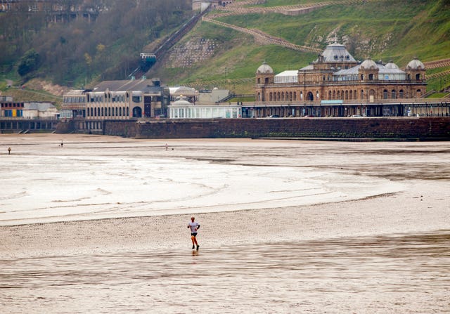 A man jogs on an empty beach in Scarborough during coronavirus restrictions in April (Danny Lawson/PA)