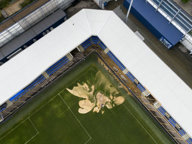 A picture of a sinkhole on the pitch and flooded walkways at the Cherry Red Records Stadium, home of AFC Wimbledon