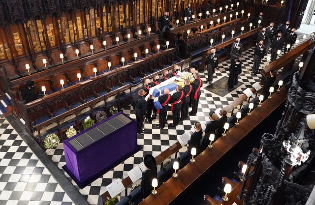 The Queen watches as pallbearers carry the coffin of the Duke of Edinburgh during his funeral at St George’s Chapel, Windsor Castle, Berkshire
