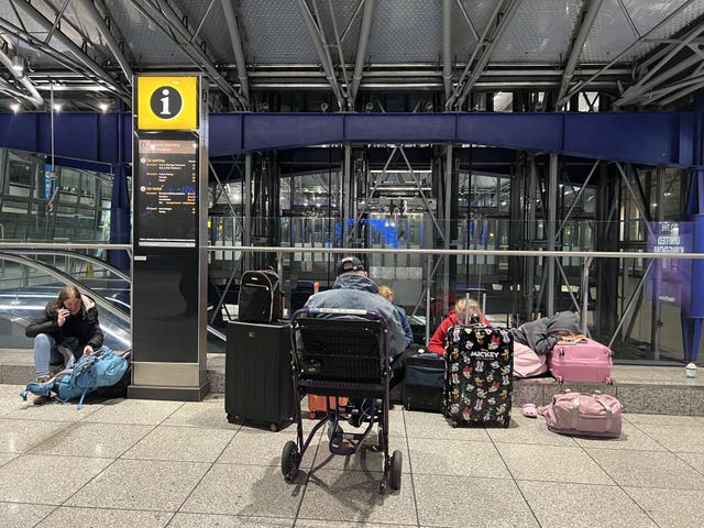 Passengers sit on the floor at Heathrow Airport