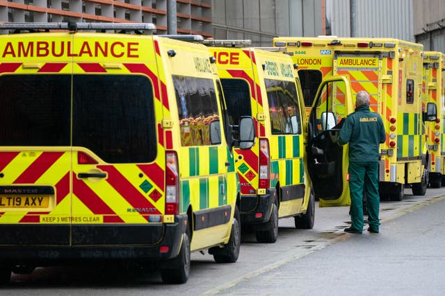 A paramedic walks past a line of ambulances outside the Royal London Hospital, in London