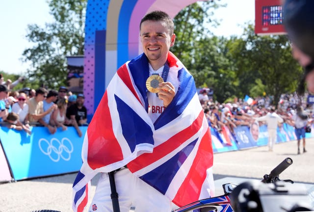 Great Britain’s Tom Pidcock poses with his gold medal following the men’s cross-country mountain bike