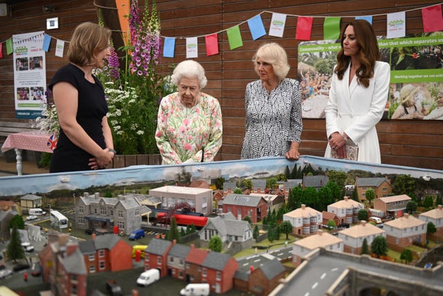 Programme director at the Eden Project, Lindsey Brummitt, shows a scale model of Big Lunch events to the royals