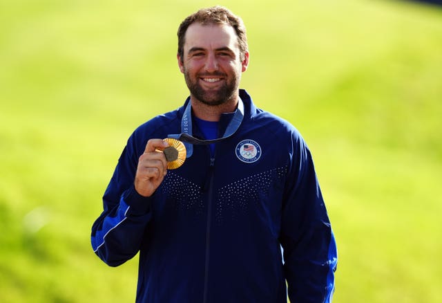 Scottie Scheffler holds his Olympic gold medal