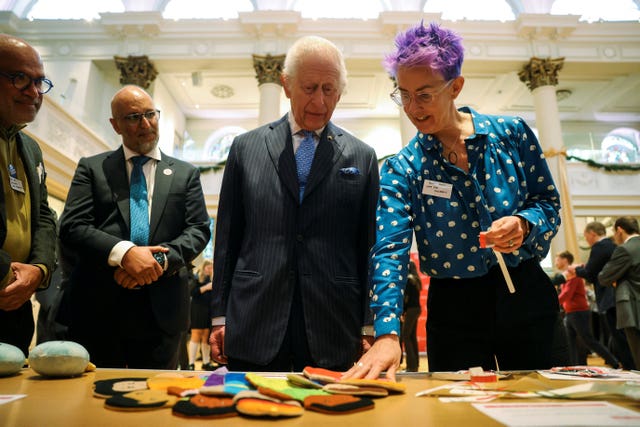 The King looking at items used in humanitarian responses alongside DEC staff