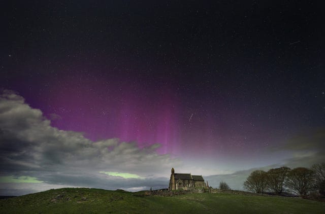 The Northern Lights illuminate the sky above a church in Northumberland