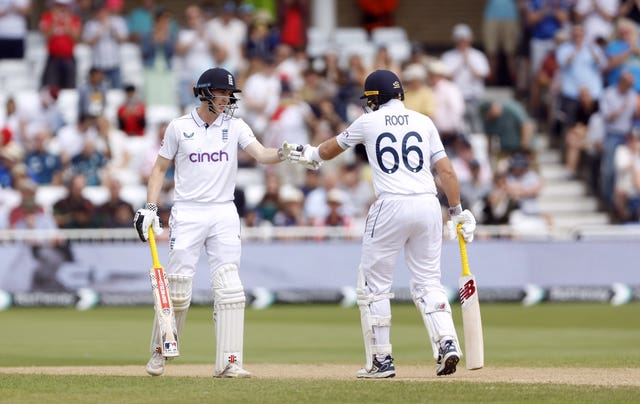 England’s Joe Root celebrates reaching his half-century against the West Indies by bumping fists with team-mate Harry Brook