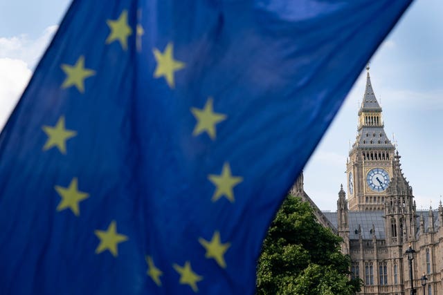 EU flag in foreground of the Elizabeth Tower in Westminster
