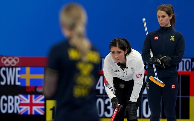 Eve Muirhead, centre, and Sweden skip Anna Hasselborg, right