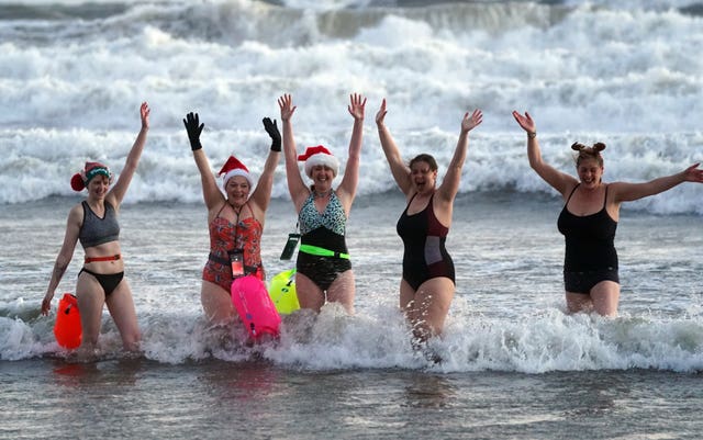 Swimmers go for a Christmas Day dip at Tynemouth beach, north-east England 
