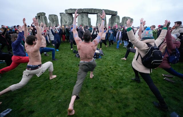 People take part in the winter solstice celebrations during sunrise at the Stonehenge prehistoric monument on Salisbury Plain in Wiltshire