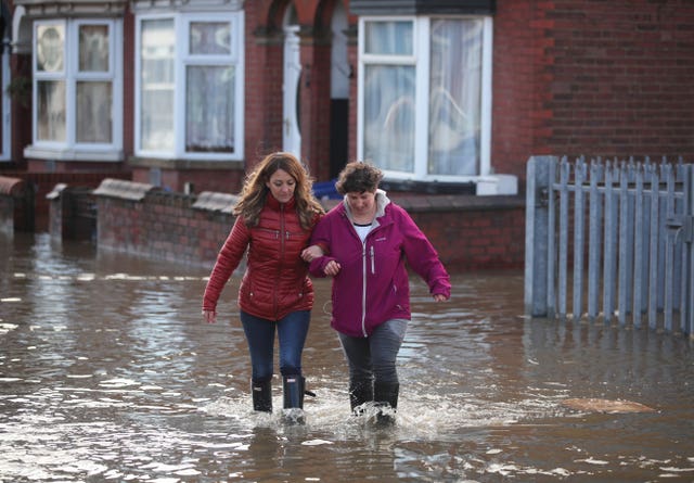 Two people walk through flood water in Doncaster