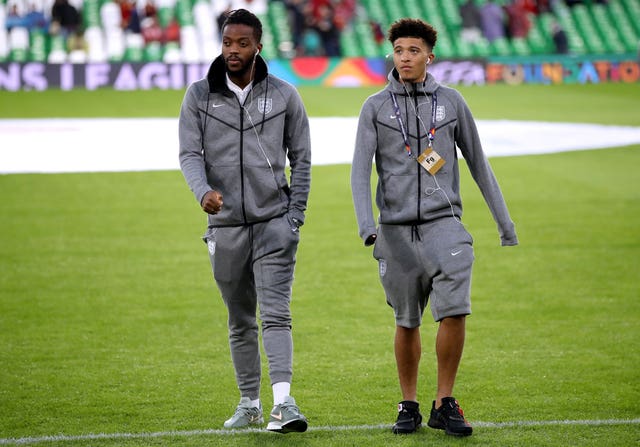 Nathaniel Chalobah, left, and Jadon Sancho walk on the pitch