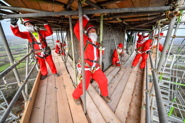 Scaffolders get into the festive spirit and dress in Santa outfits as they construct scaffold around the Wellington Monument on the Blackdown Hills