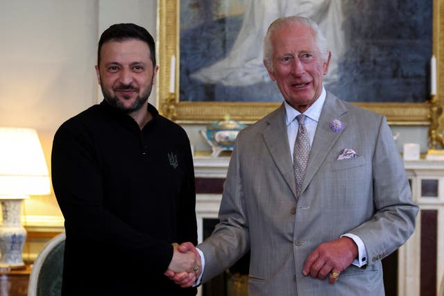 Ukrainian President Volodymyr Zelensky shakes hands with the King