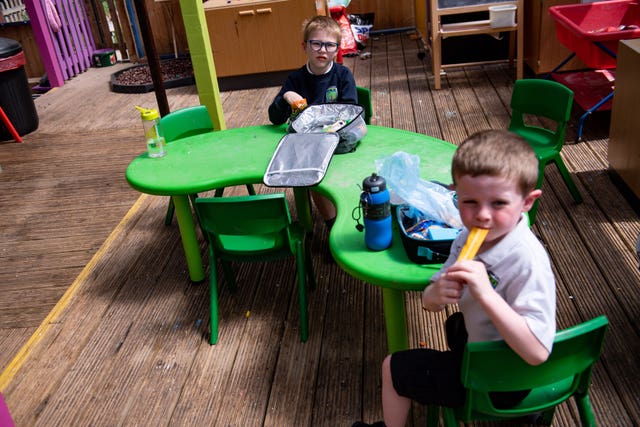 Children of essential workers eat lunch in segregated positions (Jacob King/PA)