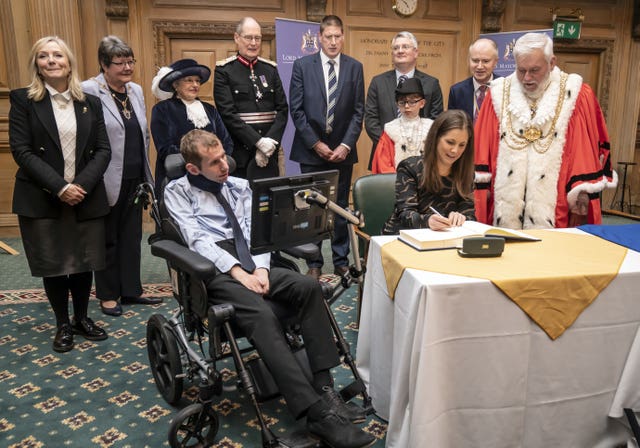 Lindsey Burrow signs the Scroll of Admission on behalf of her husband Rob Burrow