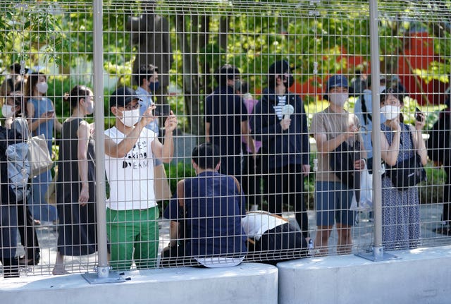 Fans catch a glimpse of the athletes from behind fences 