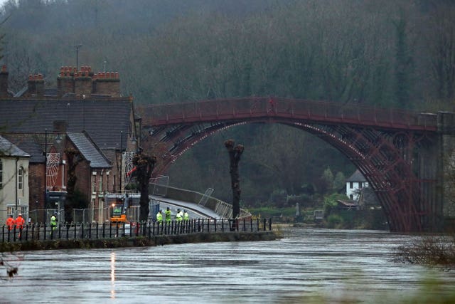 Environment Agency personnel place flood barriers on a bank of the high River Severn, near Ironbridge, Shropshire (Nick Potts/PA)